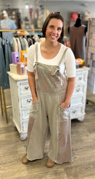 Woman wearing stone grey and patchwork overalls in a store