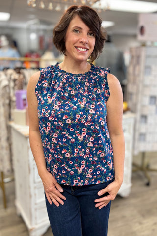 Woman wearing a floral sleeveless top in a store setting
