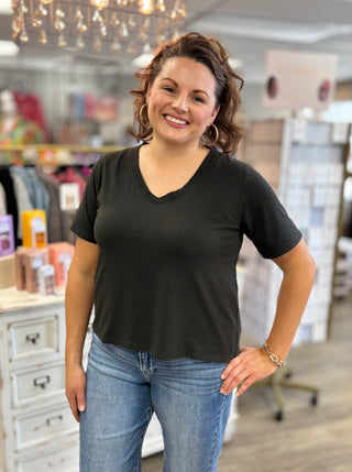 Woman wearing a black t-shirt and blue jeans standing in a store.