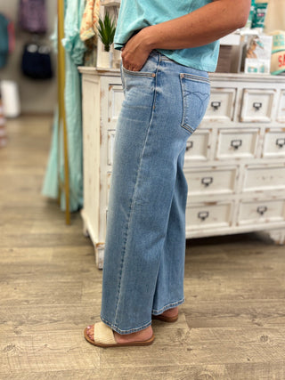 Model wearing medium wash, mid rise, ankle wide jeans