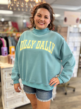 Woman wearing a light blue sweatshirt with 'Dilly Dally' text in a store setting