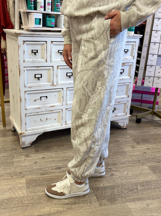 Model wearing white camo printed jogger style sweat pants 