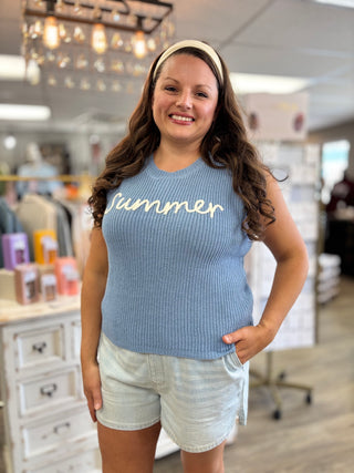 Model wearing blue knitted sweater tank with ‘summer’ embroidered detail