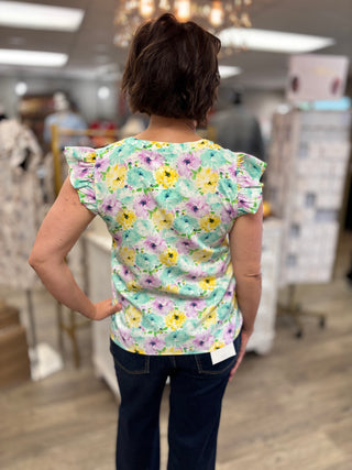 Person wearing a floral top in a store setting