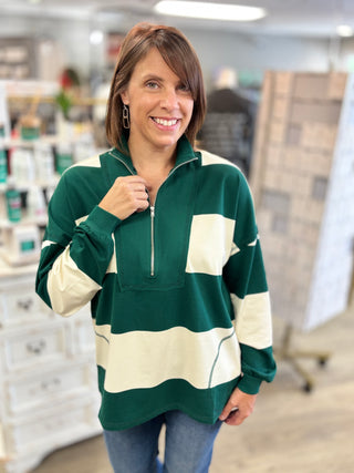 Model wearing hunter green and cream striped top with zipper detail 