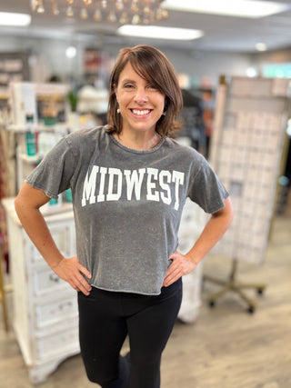 Model wearing a mineral washed t-shirt that says MIDWEST”.
