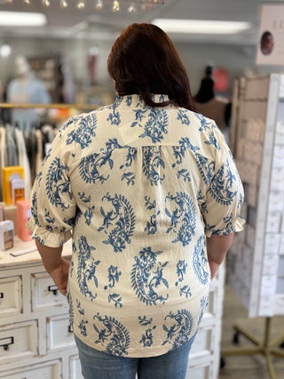 Person wearing a blue and cream patterned shirt in a store setting