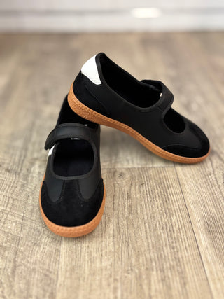 A pair of black Mary Jane style shoes with velcro closure and rubber soles