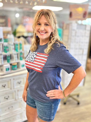 Woman wearing a blue t-shirt with an American flag design in a store setting