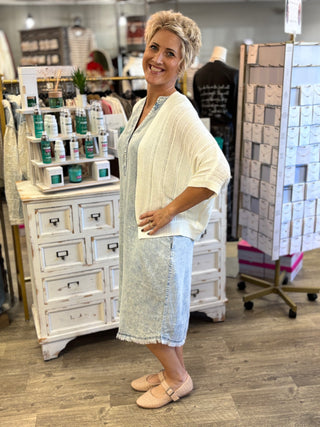Model wearing a light wash chambray dress with cardigan 