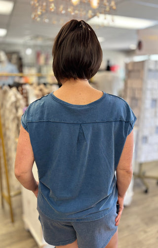 Person wearing a blue top and shorts in a store setting