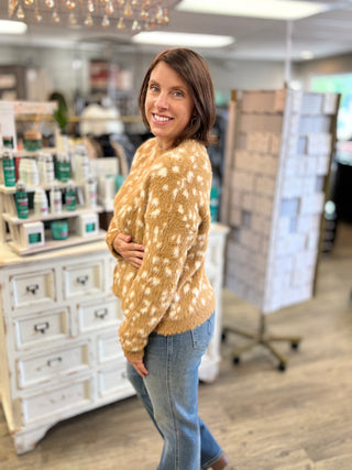 Model wearing a fawn printed sweater and jeans.