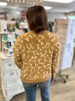 Model wearing a fawn printed sweater and jeans.
