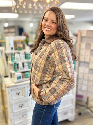 Model wearing a multi brown plaid quilted barn jacket with corduroy collar and buttons.